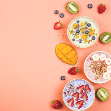 Parlak pembe arka planda kibrit ve böğürtlenli çok renkli meyve sularından yapılmış vejetaryen sağlıklı yiyecekler..