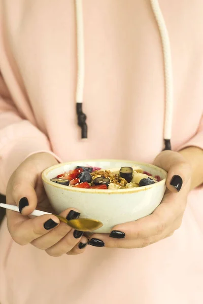 Bol à smoothie alimentaire sain avec des baies et du granola dans les mains des femmes . — Photo