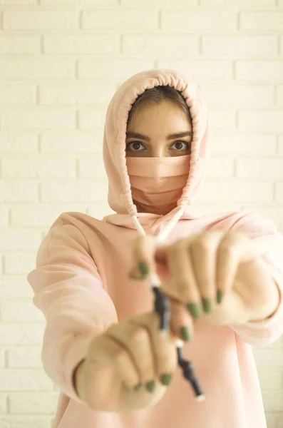 Chica en una máscara rosa para la protección contra 2019-ncov covid-19 en casa en aislamiento social . — Foto de Stock