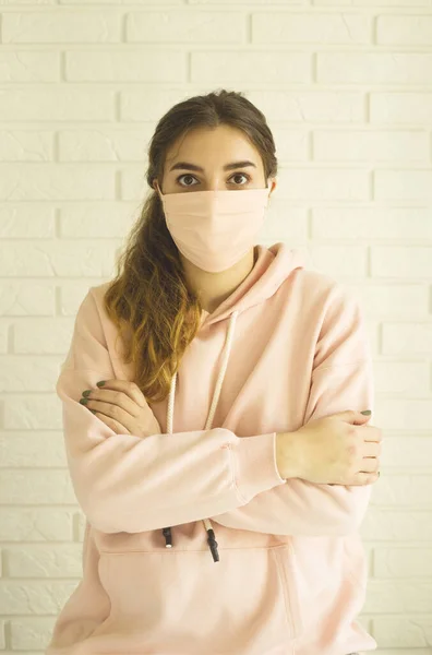 Flicka i rosa mask för skydd mot 2019-ncov covid-19 hemma i social isolering. — Stockfoto