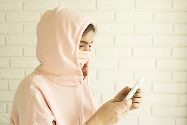 Chica en una máscara rosa para la protección contra 2019-ncov covid-19 en casa en aislamiento social . — Foto de Stock