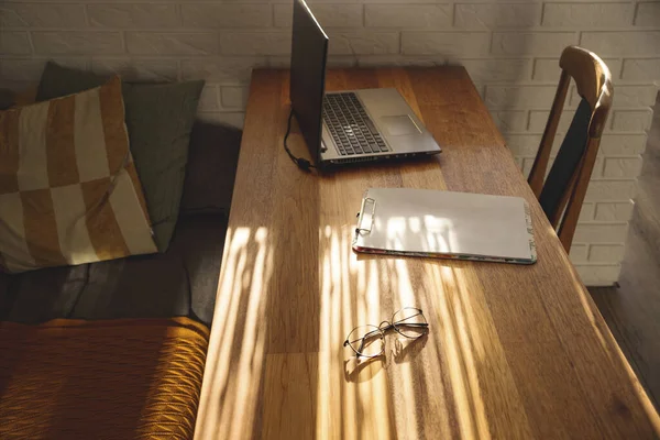 Minimalistisk arbetsplats hemma på ett träbord i skuggorna. — Stockfoto