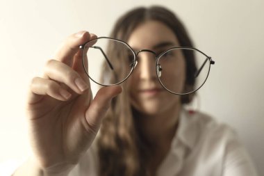 Elinde şarap kadehi tutan gözlüklü bir adam.