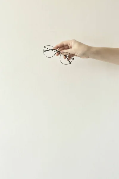 Gafas en un marco metálico delgado en las manos . — Foto de Stock