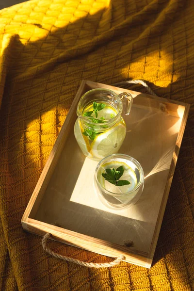 El agua con limón en un recipiente transparente en una bandeja . — Foto de Stock