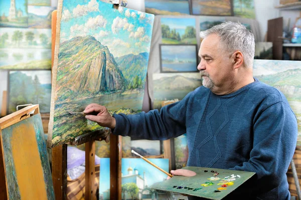 Artista pinta pintura al óleo con un pincel y una paleta — Foto de Stock