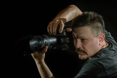 siyah arka plan üzerine bir kamera ile portre fotoğrafçısı