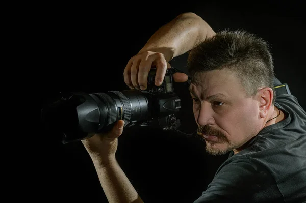 siyah arka plan üzerine bir kamera ile portre fotoğrafçısı