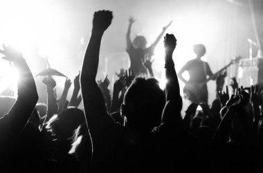parlak ışık sahne önünde bir konserde insan siluetleri