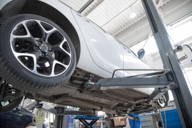 Araba tekerlek hizalama üzerinde asansör otomatik hizmetinde. Asansörde kaldırdı arabanın şasi tanısında.