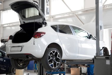 Araba tekerlek hizalama üzerinde asansör otomatik hizmetinde. Asansörde kaldırdı arabanın şasi tanısında.