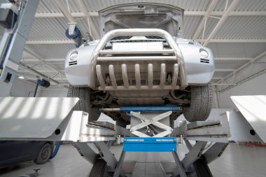 Araba tekerlek hizalama üzerinde asansör otomatik hizmetinde. Asansörde kaldırdı arabanın şasi tanısında.