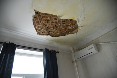 Sel yüzünden dairenin tavanı çöktü. Çatlak alçı. Hasarlı tavanın bir kısmı düşmüş..