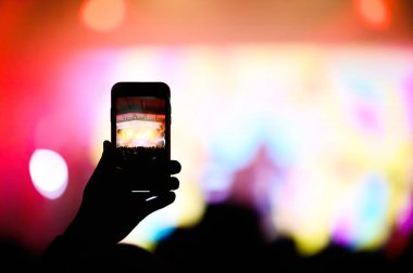 Konserdeki kalabalığın akıllı telefonuyla. Müzik festivali afişi. En sevdiğin grubun konserinde video çek.
