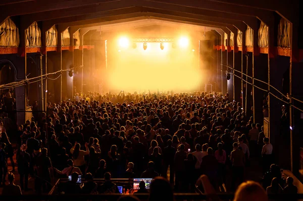 Büyük ışıklandırma sahnesi ve önündeki kalabalık. Bir müzik konserinde tam salon. Tüm festival biletleri satıldı