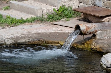 Nehre giden paslı eski kanalizasyon borusu. akış yönü. Şehir temizleme drenaj sistemi