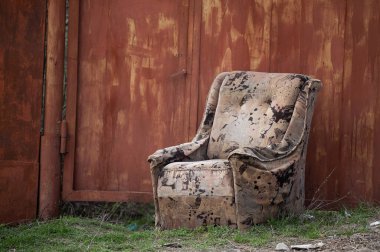 Eski, gereksiz, kolay bir sandalye sokağa atıldı. Paslı çitler. Şehrin çöplüğü olan fakir bir bölgesi. dinlenme yeri