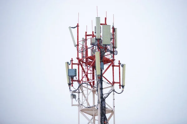 Red-white metal cell tower under the snow. communication of the population. Mobile phone Telecommunication Radio antenna Tower. Cell phone tower.