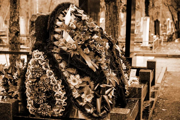墓地坟墓上的花环 由人造枝条和花朵组成 Sepia墓地的照片亲属对死者的尊重 — 图库照片