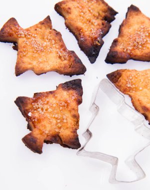 Noel ağacı şeklinde kurabiye ve beyaz arka plan üzerinde bir çerez kesici