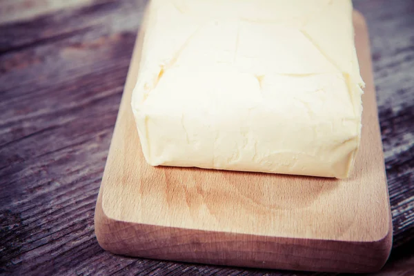 Butter on a wooden chopping board — Stock Photo, Image