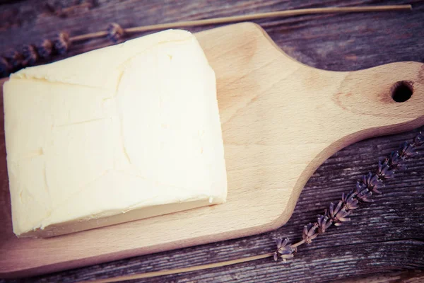 Manteiga em uma tábua de cortar madeira — Fotografia de Stock
