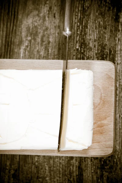 Manteiga em uma tábua de cortar madeira — Fotografia de Stock