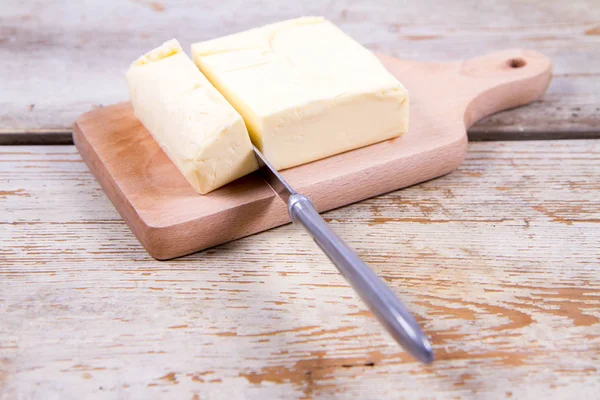 Masło na drewniana deska do krojenia — Zdjęcie stockowe