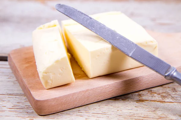 Mantequilla en una tabla de cortar de madera — Foto de Stock