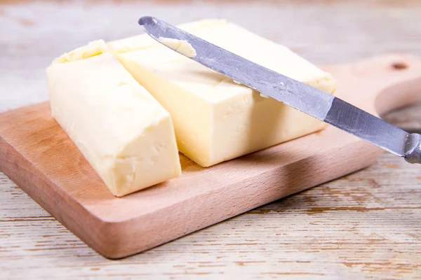 Mantequilla en una tabla de cortar de madera — Foto de Stock