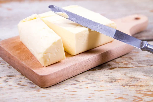 Masło na drewniana deska do krojenia — Zdjęcie stockowe