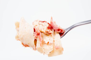 Pappardelle'i krem, kurutulmuş domates ve bir çatal üzerinde füme balık