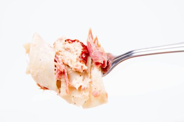 Pappardelle'i krem, kurutulmuş domates ve bir çatal üzerinde füme balık