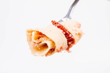 Pappardelle'i krem, kurutulmuş domates ve bir çatal üzerinde füme balık