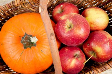 Sepeti ahşap arka plan üzerinde bir kabak ve elma dolu