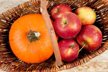 Sepeti ahşap arka plan üzerinde bir kabak ve elma dolu