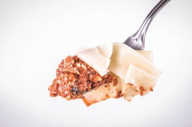 Pappardelle'i bolognese üzerinde beyaz bir arka plan üzerinde bir çatalı ile