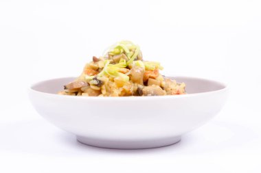 Risotto mantar ve beyaz zemin üzerine pırasa ile dekore edilmiş tavuk 