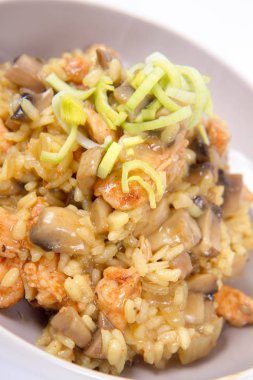 Risotto mantar ve beyaz zemin üzerine pırasa ile dekore edilmiş tavuk 