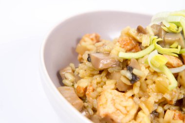 Risotto mantar ve beyaz zemin üzerine pırasa ile dekore edilmiş tavuk 