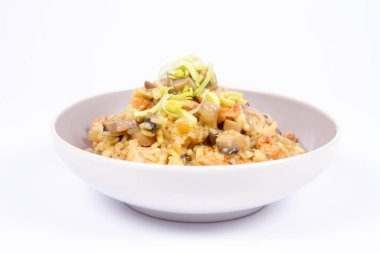 Risotto mantar ve beyaz zemin üzerine pırasa ile dekore edilmiş tavuk 