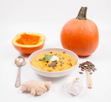 Balkabağı çorbası ve kabak, kabak çekirdeği, zencefil ve sarımsak beyaz bir arka plan üzerinde
