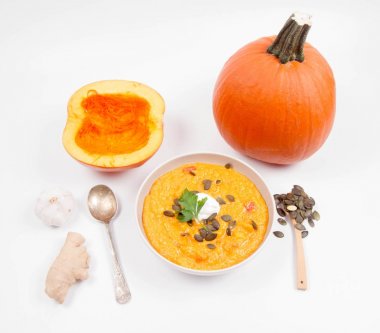 Balkabağı çorbası ve kabak, kabak çekirdeği, zencefil ve sarımsak beyaz bir arka plan üzerinde