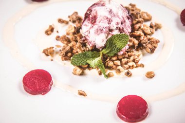 Kepçe dondurma kavrulmuş fındık üzerine nane ve ahududulu jöle ile dekore edilmiş