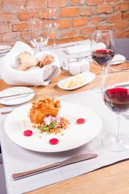 Lehçe-Litvanyaca geleneksel bir restoranda taze nane ile dekore edilmiş dondurma, kavrulmuş fındık ve ahududulu jöle ile pasta ('ağaç kek') - sekacz (Polonya) veya sakotis (Litvanyaca) tükürmek