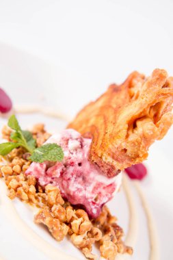 Lehçe-Litvanyaca geleneksel beyaz zemin üzerine taze nane ile dekore edilmiş dondurma, kavrulmuş fındık ve ahududulu jöle ile pasta ('ağaç kek') - sekacz (Polonya) veya sakotis (Litvanyaca) tükürmek