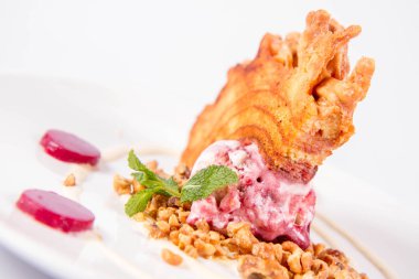 Lehçe-Litvanyaca geleneksel beyaz zemin üzerine taze nane ile dekore edilmiş dondurma, kavrulmuş fındık ve ahududulu jöle ile pasta ('ağaç kek') - sekacz (Polonya) veya sakotis (Litvanyaca) tükürmek