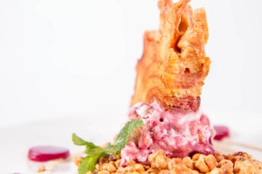 Lehçe-Litvanyaca geleneksel beyaz zemin üzerine taze nane ile dekore edilmiş dondurma, kavrulmuş fındık ve ahududulu jöle ile pasta ('ağaç kek') - sekacz (Polonya) veya sakotis (Litvanyaca) tükürmek