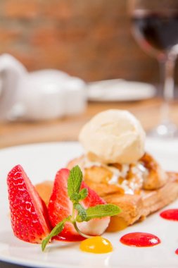 Elmalı turta dondurma çilek ile dekore edilmiş meyve sosu ve bitki bir restoranda servis