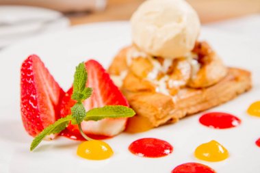 Elmalı turta dondurma çilek ile dekore edilmiş meyve sosu ve bitki bir restoranda servis